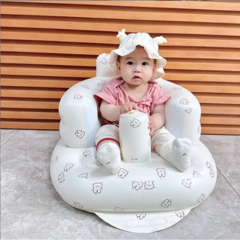 Baby sitting in white inflatable dining bath chair