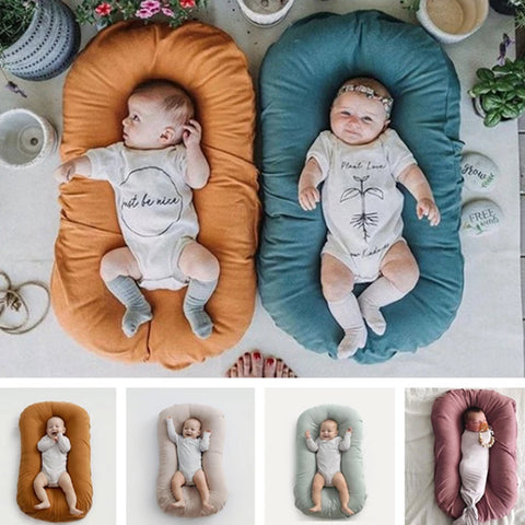 Newborn baby lying in portable cotton nest bed